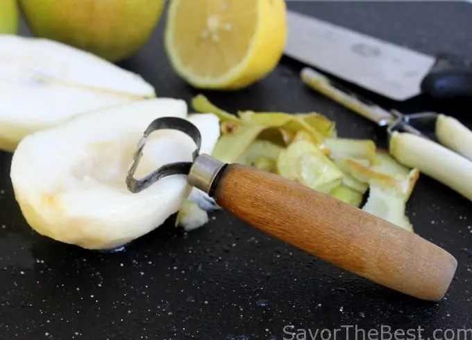 a sliced and cored pear with a pear corer 