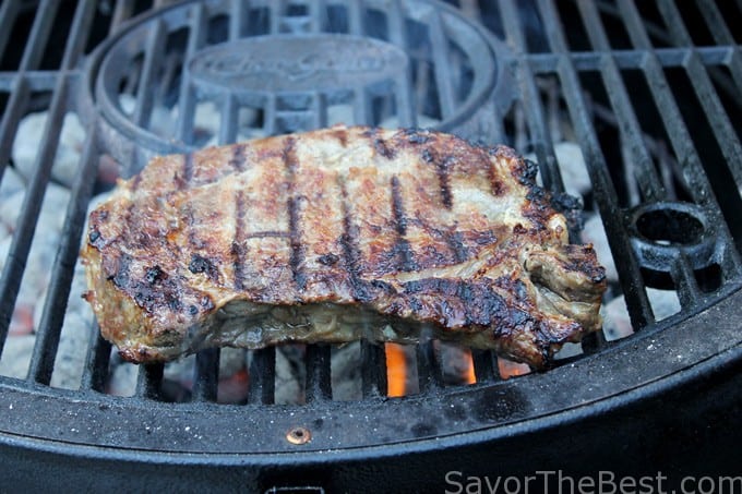 A ribeye steak on a grill.