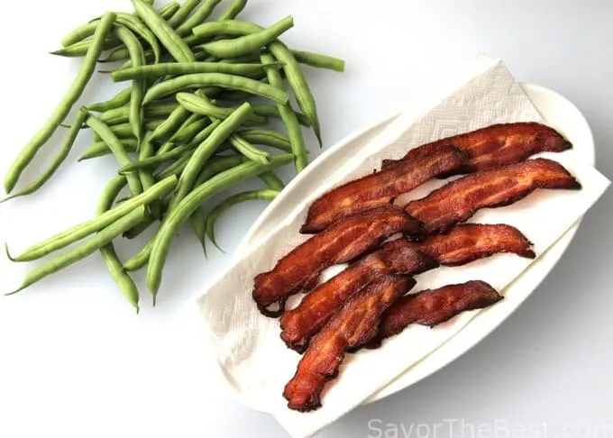 Green Beans next to crisp bacon strips. 