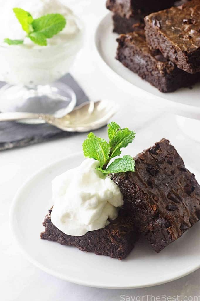 A plate with an einkorn brownie topped with whipped cream. 