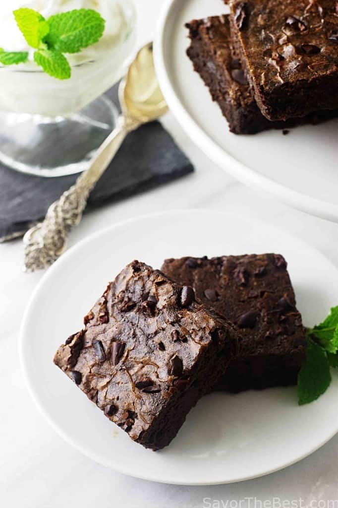 Einkorn flour brownies on a small plate with a larger platter in the background. 