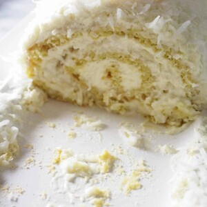 A coconut roll Swiss cake on a white platter.