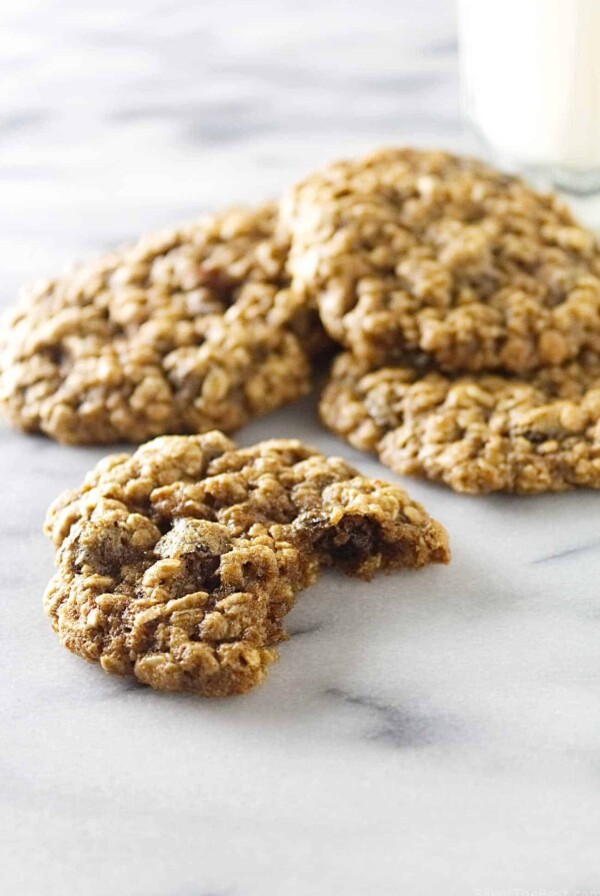 Several oatmeal raisin spelt cookies on a marble counter.