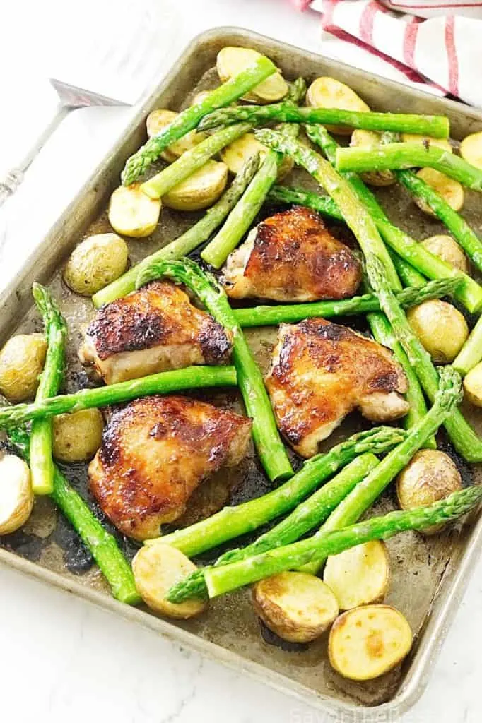 easy Sheet Pan Chicken Dinner! Roasted chicken thighs, small Yukon potatoes and tender fresh asparagus.  Dinner on the table in thirty-minutes flat!
