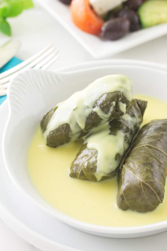 Stuffed Grape Leaves with lamb (Dolmas) and Avgolemono Sauce.