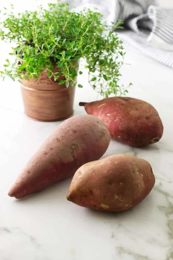 Several sweet potatoes ready to be peeled. 