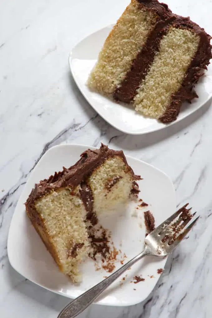 two slices of yellow cake with chocolate frosting