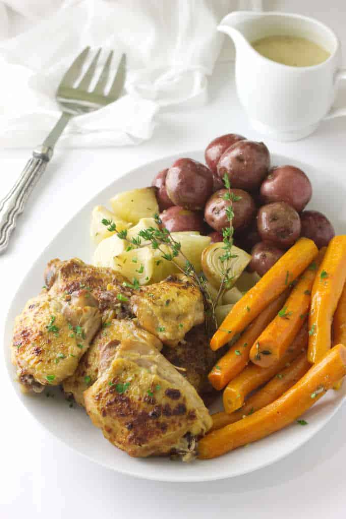 Crockpot Chicken and Vegetables served on a platter with a pitcher of gravy