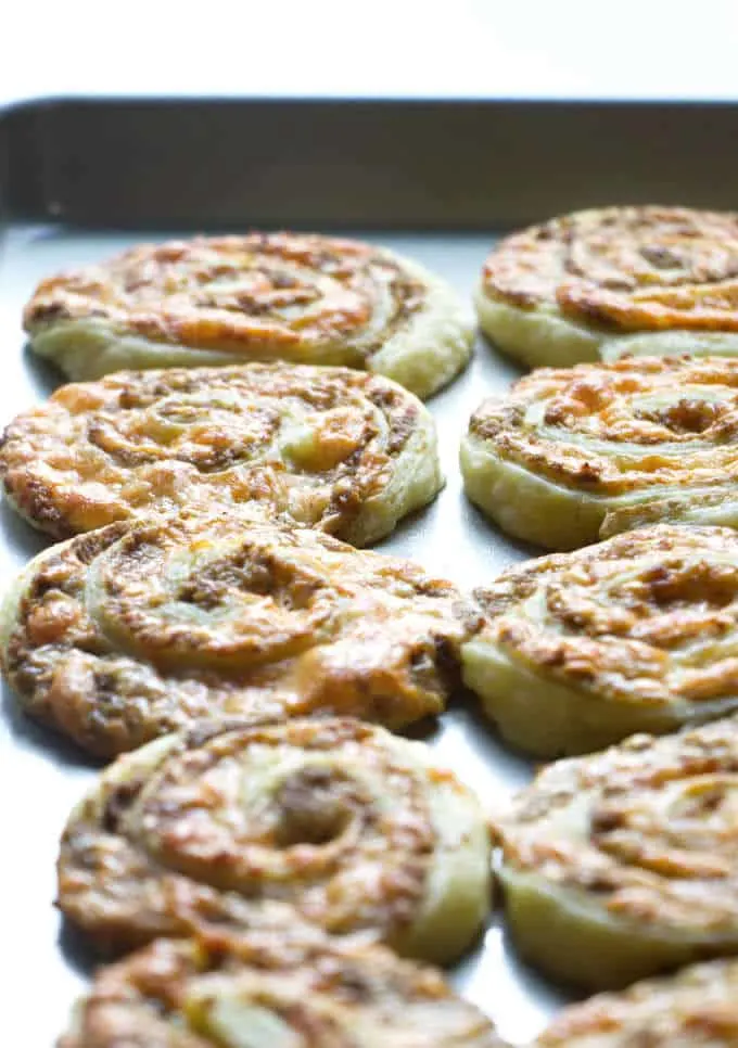 Olive and cheese pinwheel appetizers on a baking sheet