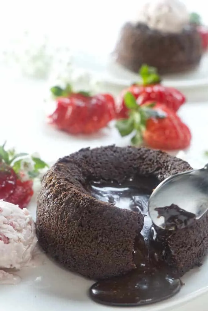 molten chocolate lava cake with strawberries in the background