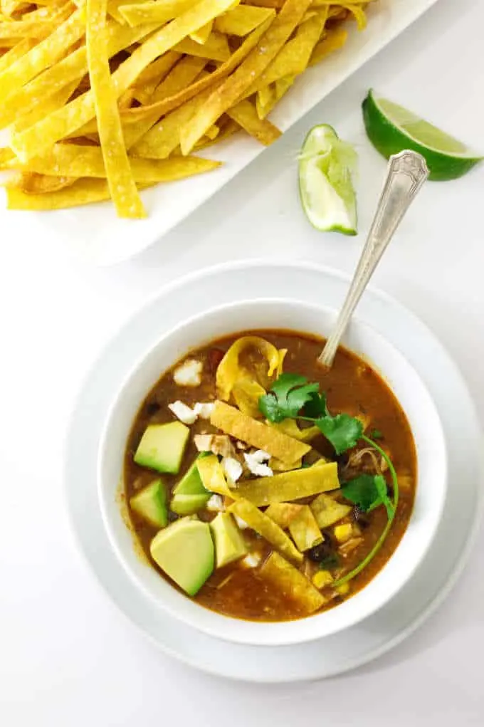 overhead view of chipotle chicken tortilla soup with tortilla strips