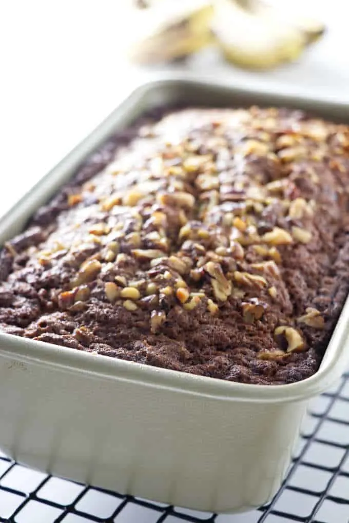 loaf of banana bread in a pan with nuts on top