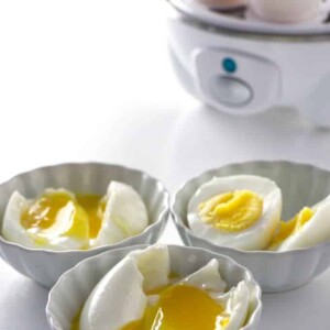 an egg cooker with shelled eggs in front