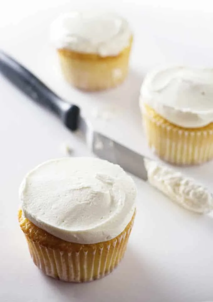 cupcakes and a spatula with buttercream on it