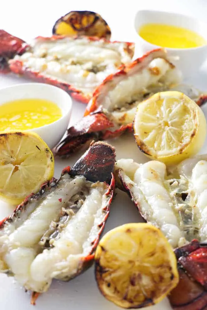 four lobster tails with four grilled lemons