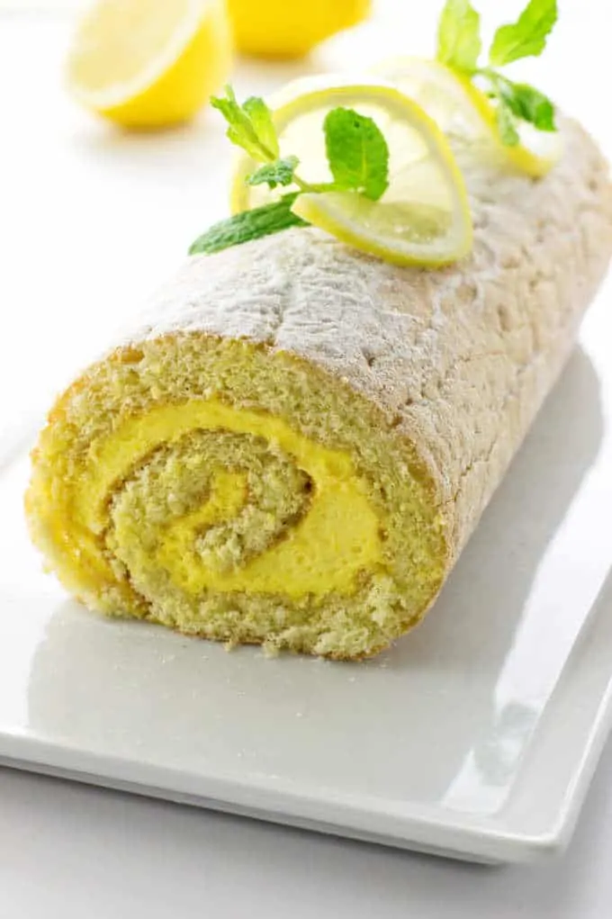 Lemon Cake Roll on a serving platter with garnish