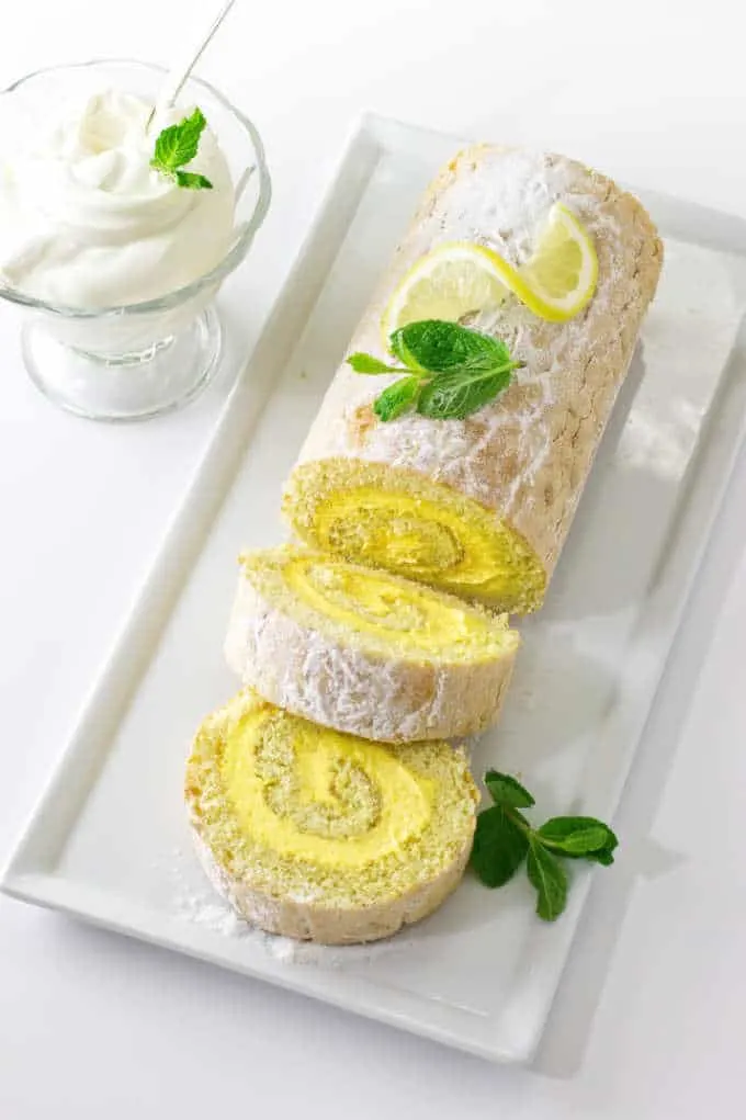 Lemon cake roll on sliced on a serving platter