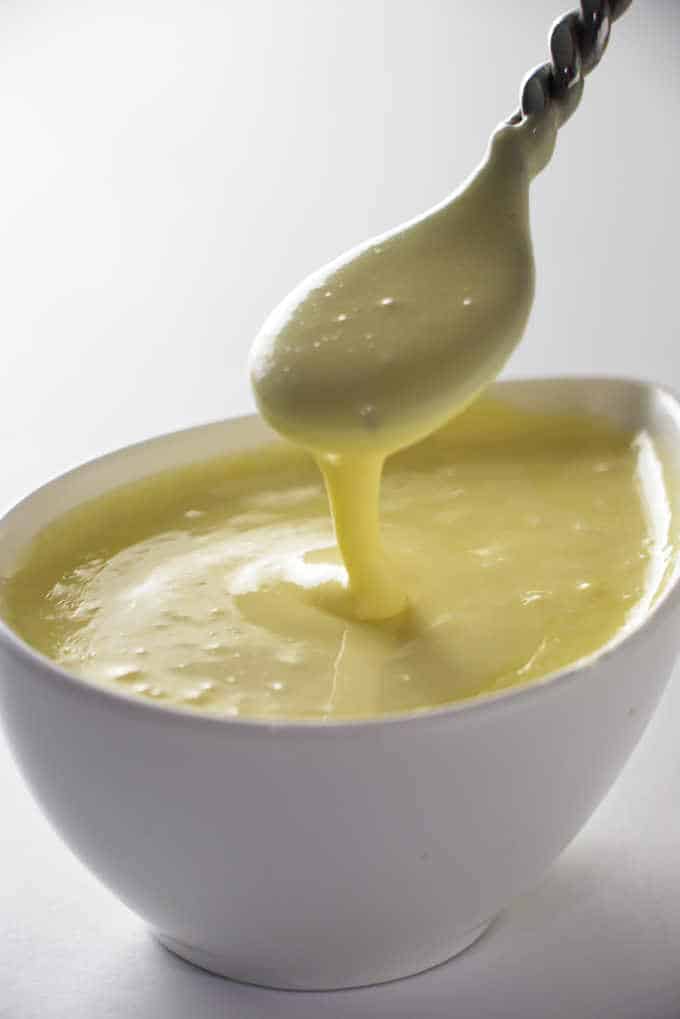 a dish of hollandaise sauce with a spoon in the dish