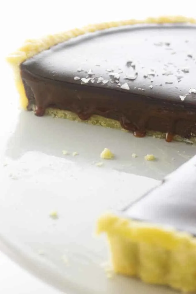 a close-up photo of Chocolate Caramel Tart with the caramel drizzling over the edge