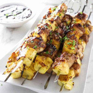 a plate of grilled pineapple chicken kabobs