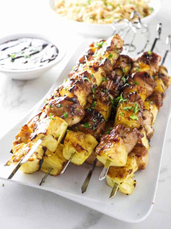 a plate of grilled pineapple chicken kabobs