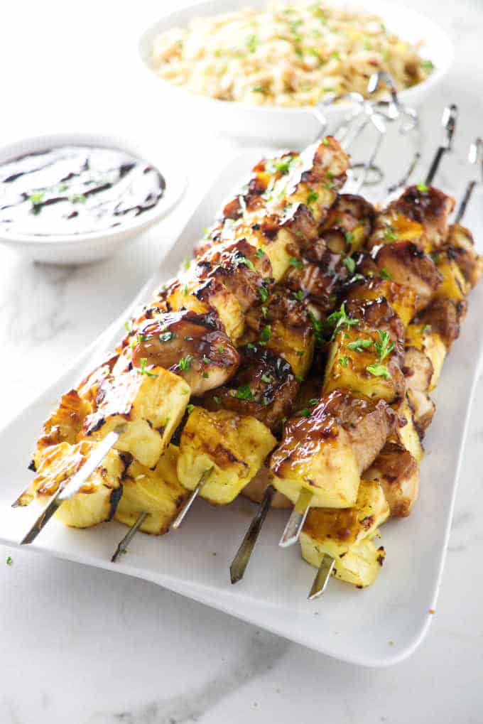 a plate of grilled pineapple chicken kabobs