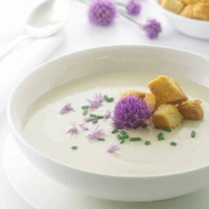 A serving of soup with chive blossoms