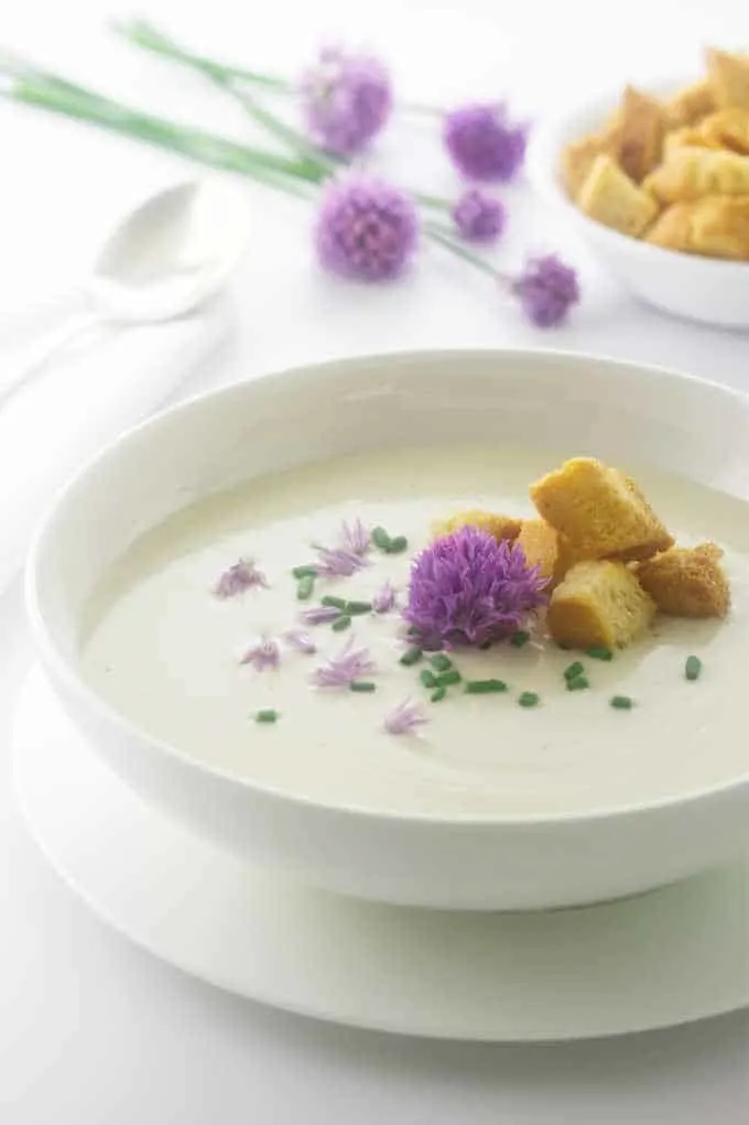 A serving of soup with chive blossoms