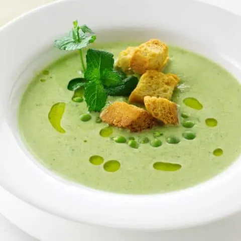 A bowl of fresh green pea soup and mint soup with garnish