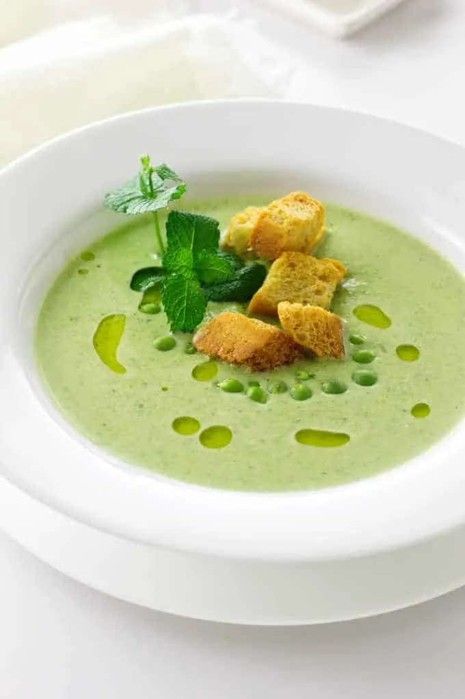 A bowl of fresh green pea soup and mint soup with garnish