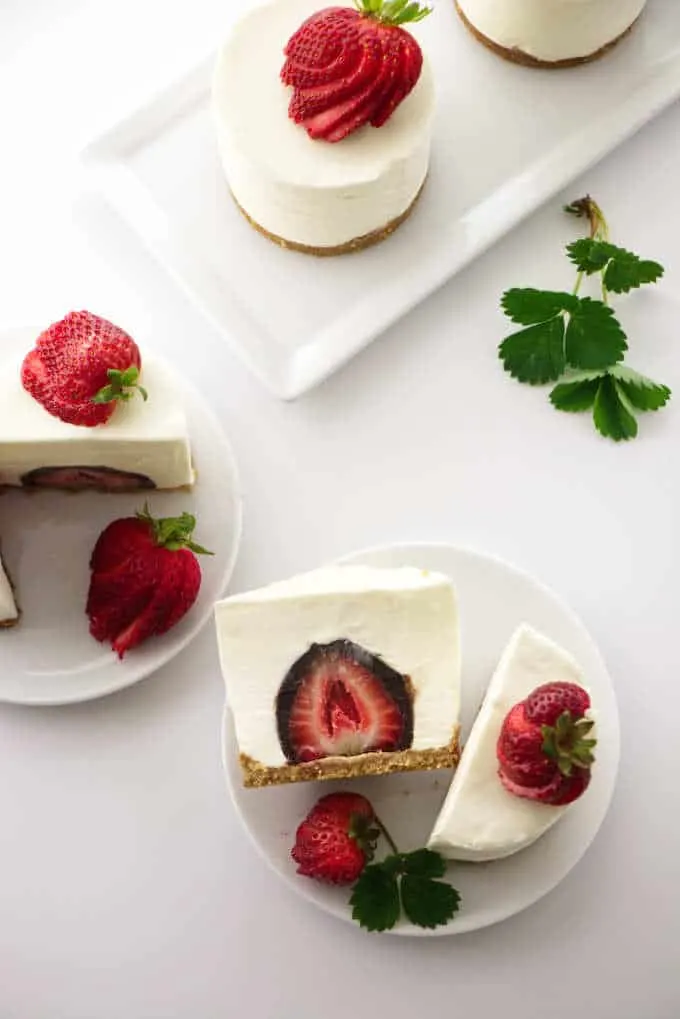 overhead photo of individual cheesecakes with a chocolate covered strawberry in the center