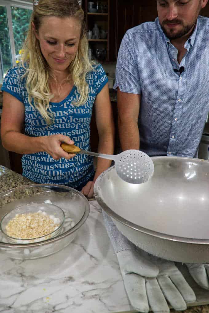 scooping ice cream dots out of liquid nitrogen with a slotted spoon