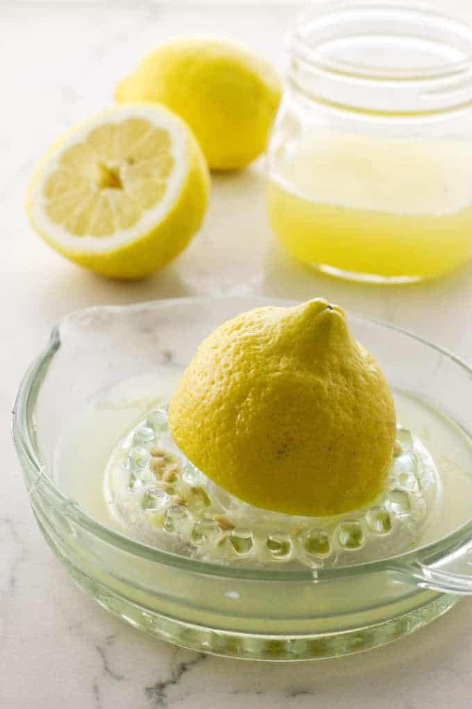 Lemon being juiced, lemon juice in jar