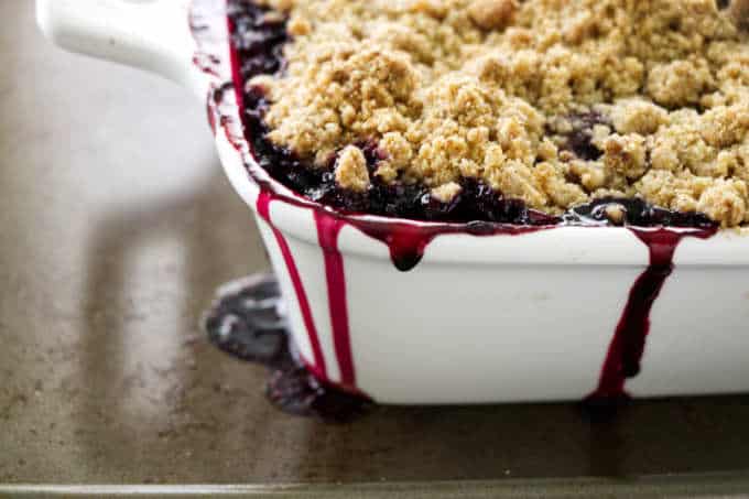 Blackberry crumble fresh out of the oven with juices dripping down the side of the dish