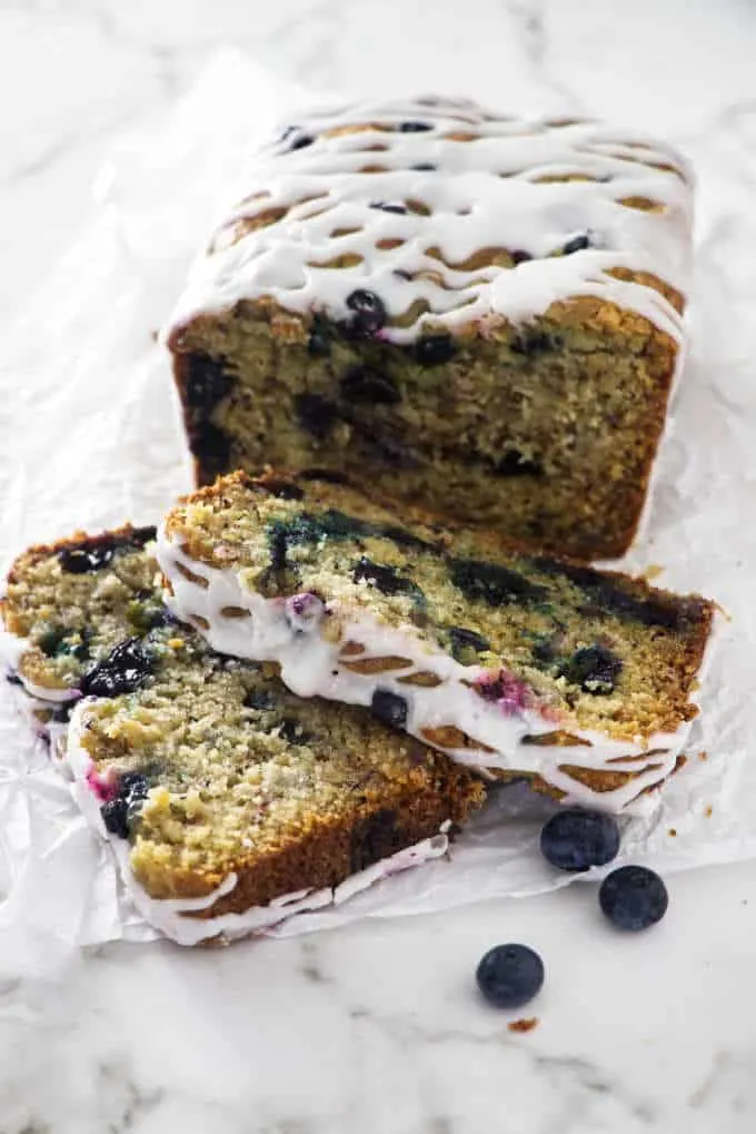 blueberry banana bread with two sliced in the foreground 