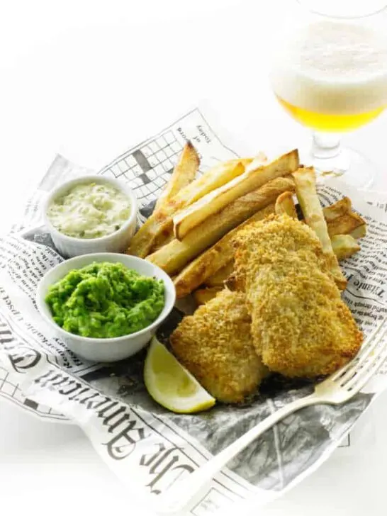 Oven fries, baked fish, mushy peas, tartar sauce and glass of beer