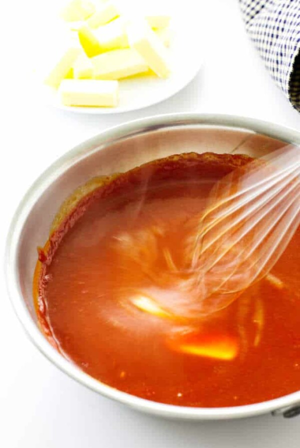 Buffalo sauce with butter being whisked in