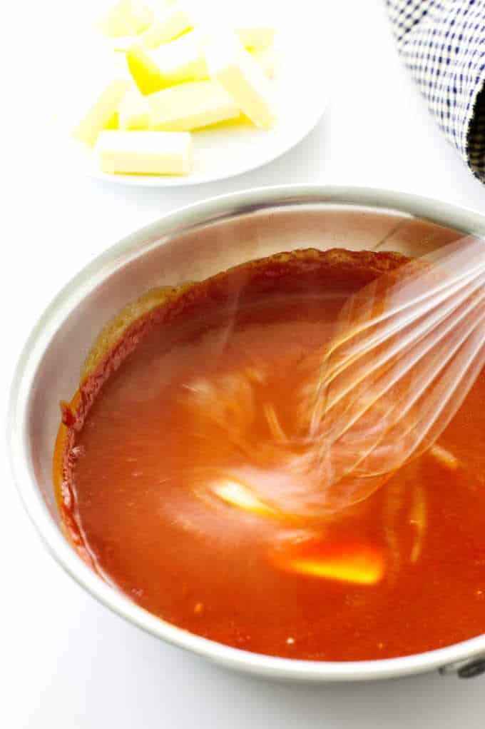 Buffalo sauce with butter being whisked in