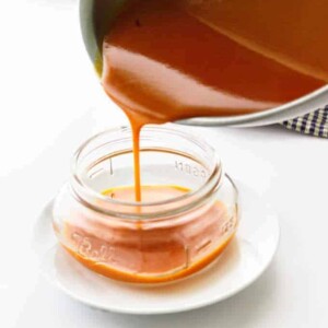 Buffalo Sauce being poured into a Mason jar