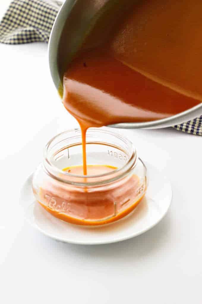 Buffalo Sauce being poured into a Mason jar