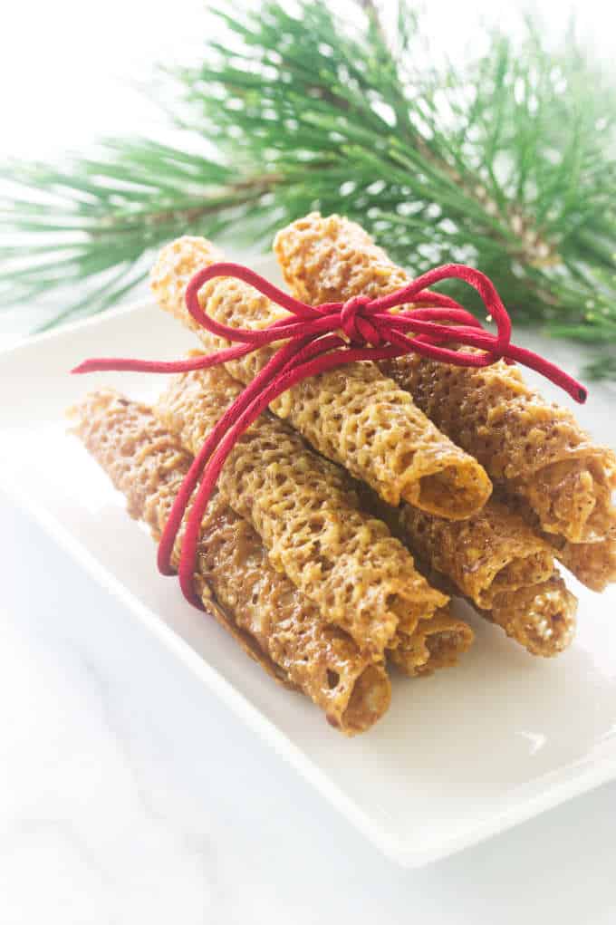 Plate of cigar-shaped florentine cookies with red ribbon