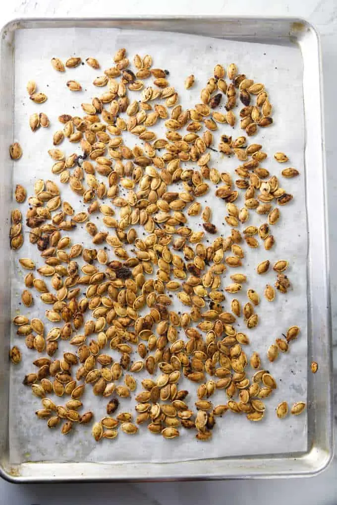 Roasted pumpkin seeds on a baking sheet.