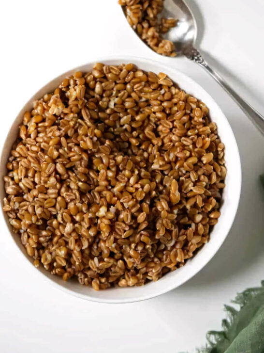 A bowl of instant pot farro with a spoon.