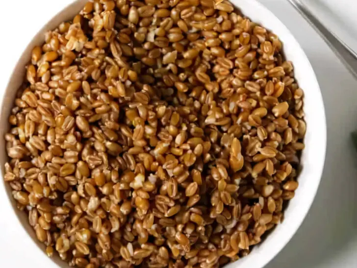 A bowl of instant pot farro with a spoon.