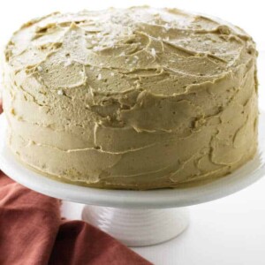 Cake on pedestal with salt being sprinkled on top.