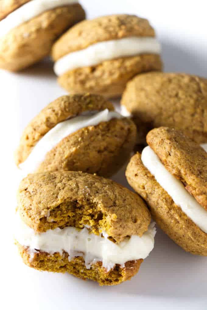 six pumpkin whoopie pies filled with cream cheese frosting