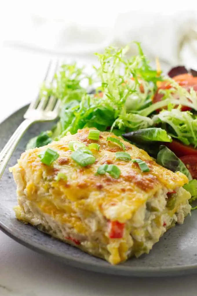 serving of chicken tortilla casserole on plate with salad and fork