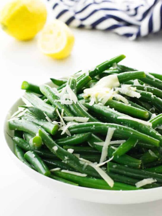 A bowl of steamed green beans with parmesan cheese