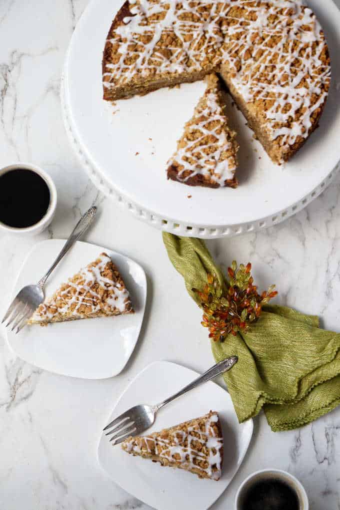 Overhead view of a fresh pear cake on a serving plate and two slices on smaller plates.