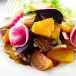 Serving of beet salad on plate with fork and napkin